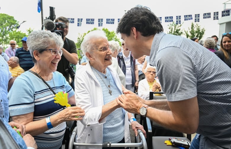 Prime Minister Justin Trudeau greets 99-year-old Sebastienne Germain, centre, during a Fte Nationale event at a seniors residence in Trois-Rivieres, Que., Monday, June 24, 2024.