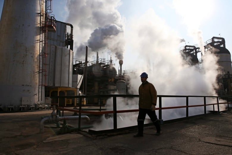 An Iranian oil worker walks in Tehran's oil refinery south of the capital Tehran, Iran, Monday, Dec. 22, 2014. 