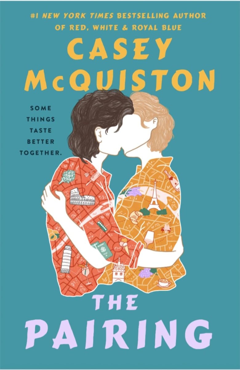 A teal book cover with two people kissing on the cover wearing shirts with European landmarks on it. 