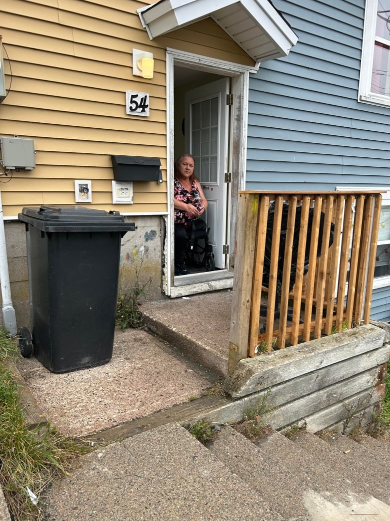 Rhonda Whalen inside her house, looking out the front door.