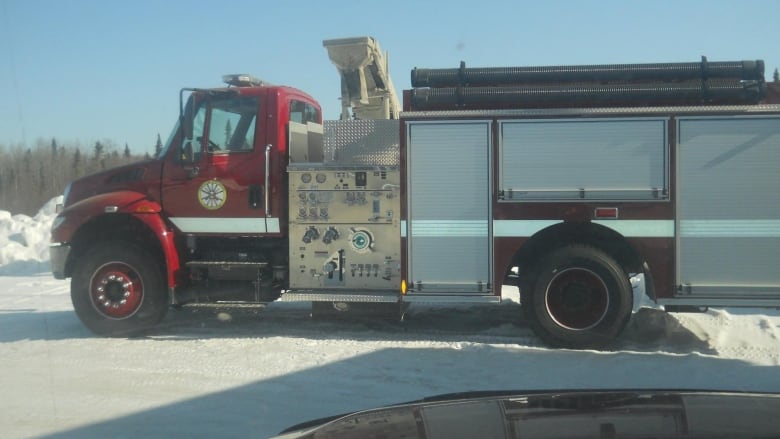 A fire truck is seen in a snowy place outside.