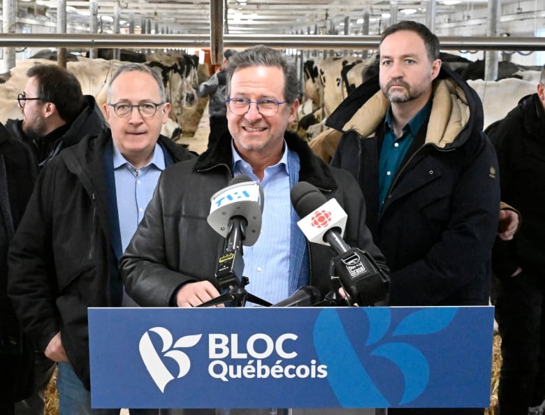 Bloc Quebecois Leader Yves-Francois Blanchet is flanked by members of his parliamentary caucus as he speaks from behind a BQ podium set up in a dairy barn in the Saguenay region of Quebec last winter.