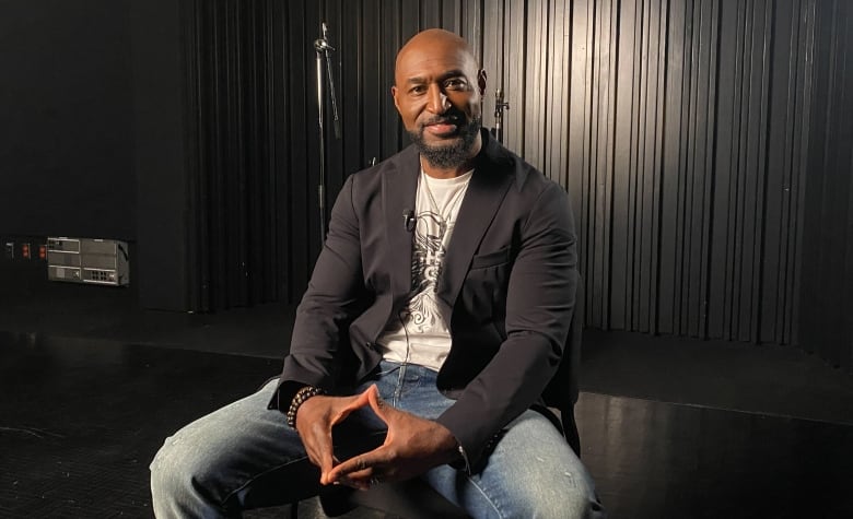 A man sitting in a chair poses for the camera. 