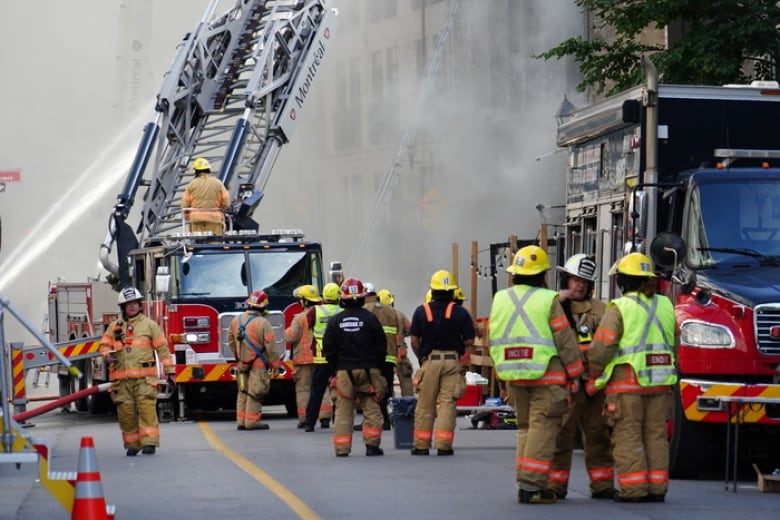 Firefighters around a smokey building. 