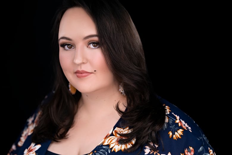 Head and shoulders profile of a woman with long dark hair against a black background.