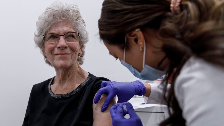 Pharmacist administers a dose of Moderna Spikevax COVID-19 vaccine in Toronto on Oct. 4.