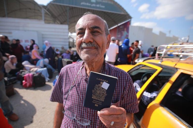 A man holds up a canadian passport