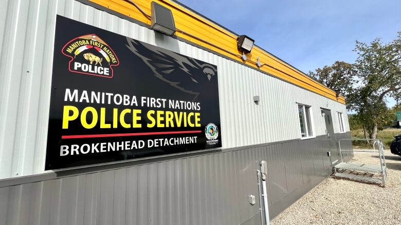 A grey portable building with the Manitoba First Nations Police Service sign outside. 