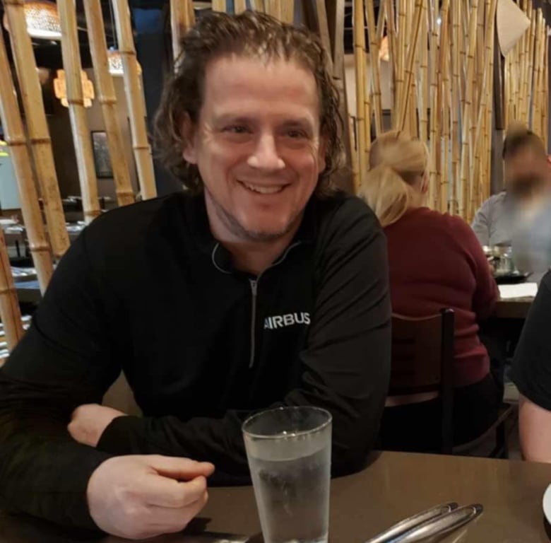 A man sitting at a dinner table smiling.