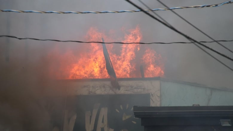 Flames and smoke are seen above a building.