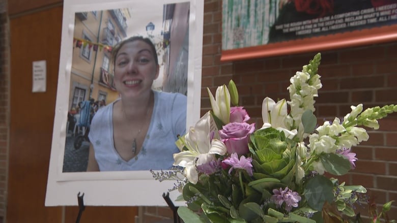 Photograph of a smiling woman displayed next to a bouquet of flowers