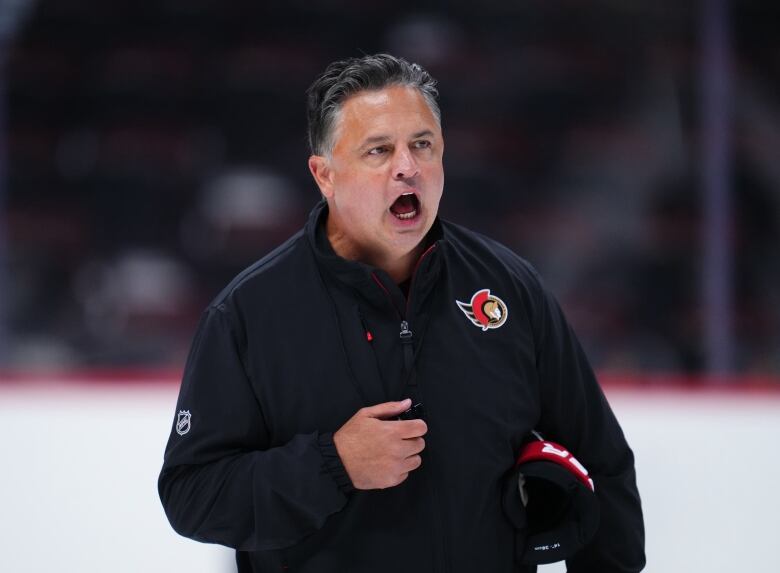 A hockey coach yells during a practice.