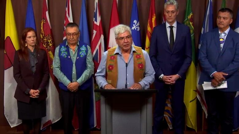 five people standing at a podium