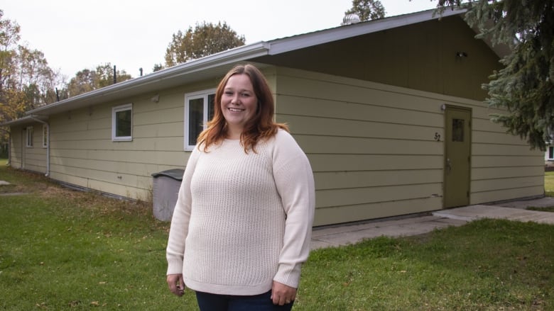 A woman stands outside a building.