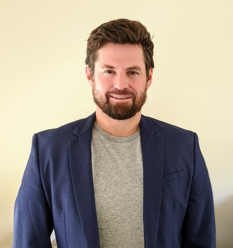 Portrait of a smiling bearded man in a blue suit jacket