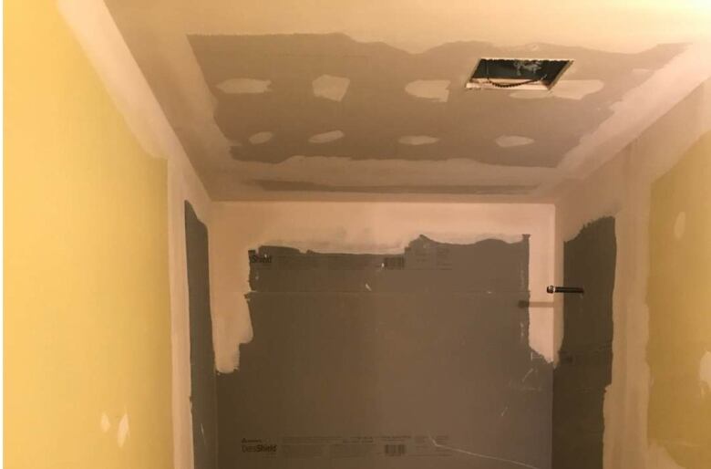 Drywall on the ceiling of a bathroom is marked with white compound.