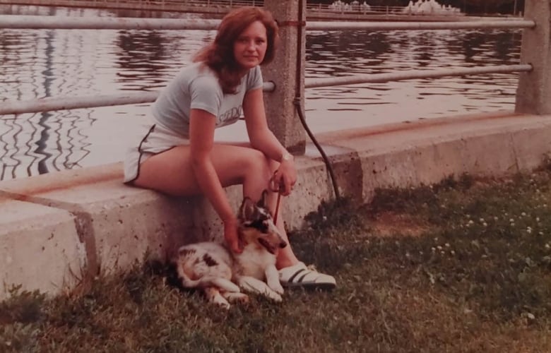 Woman sitting with dog outside.