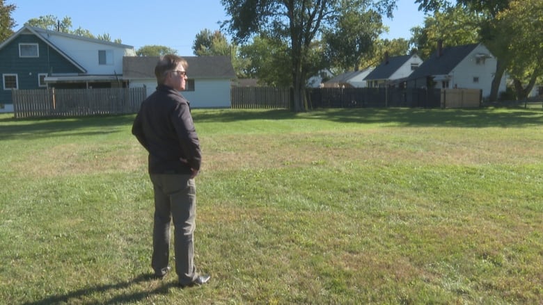 A man looks over a neighbourhood park.