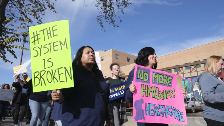 People hold signs that say 