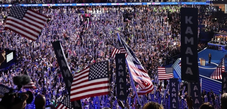 Packed arena with U.S. flags being waved 