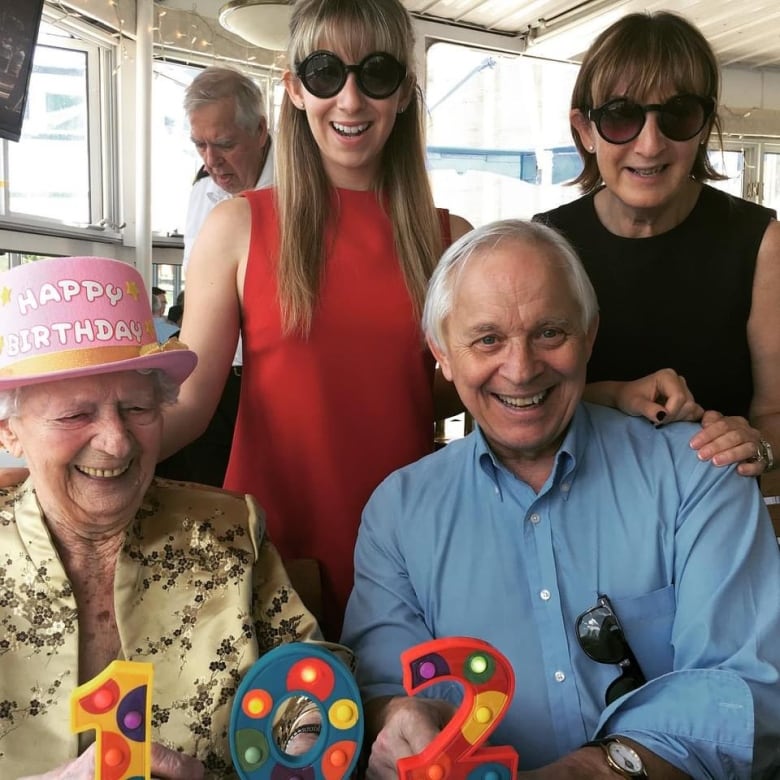 Four people smiling for the camera, an elderly woman, a man and two younger women.