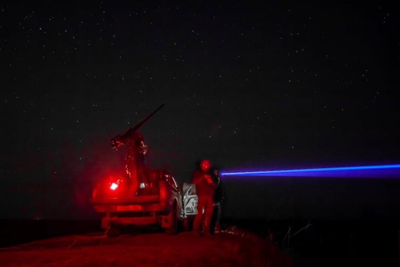 Ukrainian soldiers look for Russian drones during an air alert in Ukraine's Kherson region.