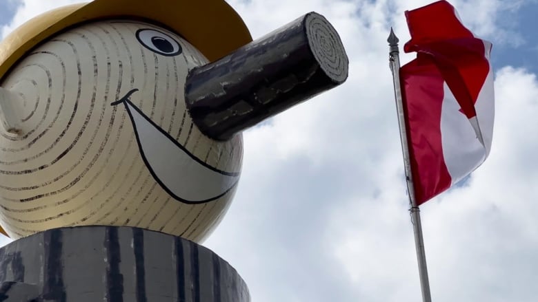 A closeup of a smiling wooden face.