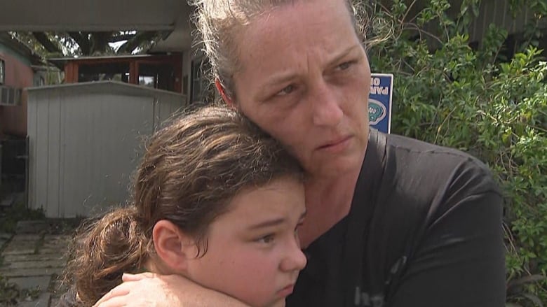 A woman and daughter embrace.