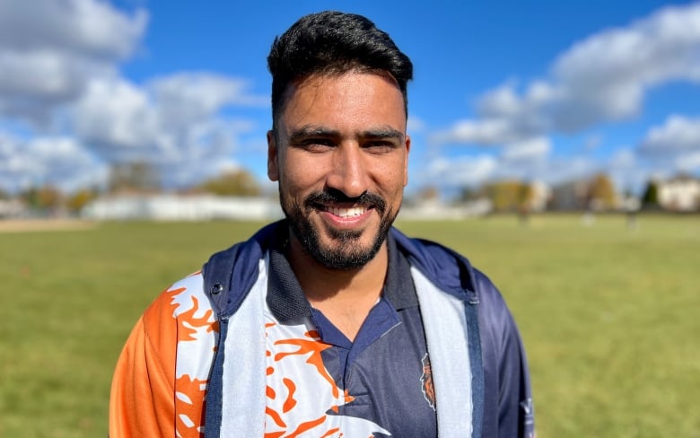 A man wearing a sports uniform smiling