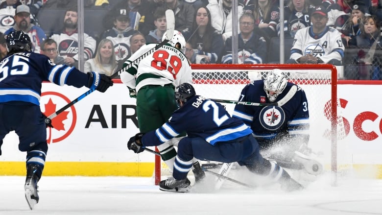 Hockey players converging near the net.