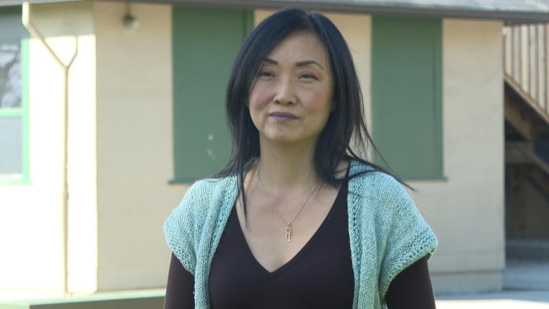 An East Asian woman looks to her left on a sunny day.