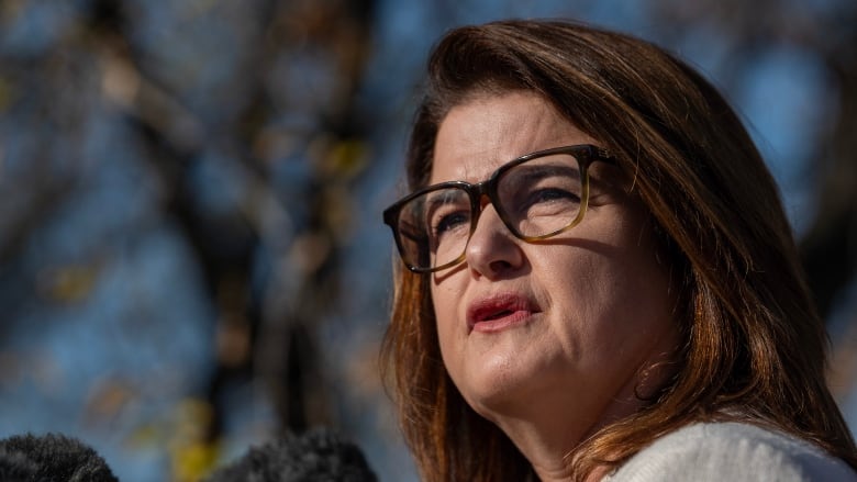 A close-up of a woman in glasses.