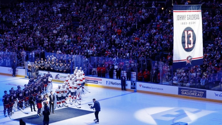 Players watch as a banner is raised.