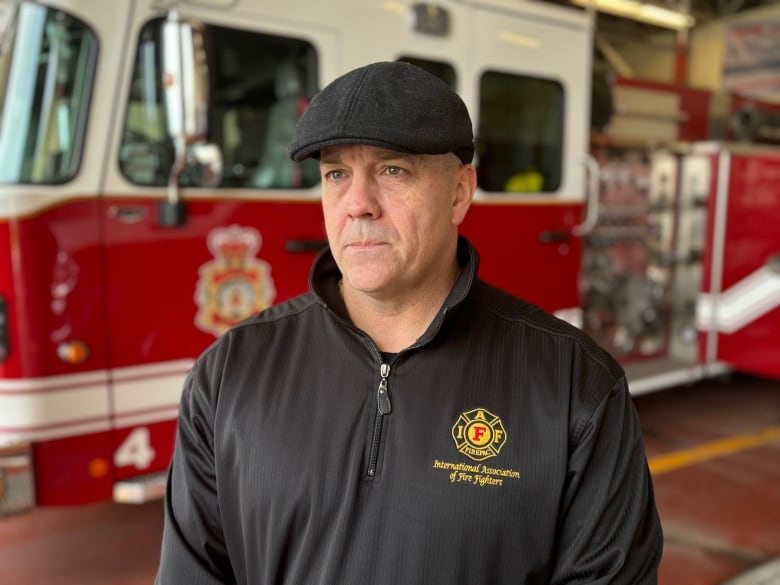 A person stands in front of a fire truck.