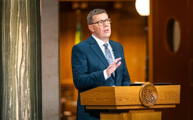 A man speaks while standing at a podium.