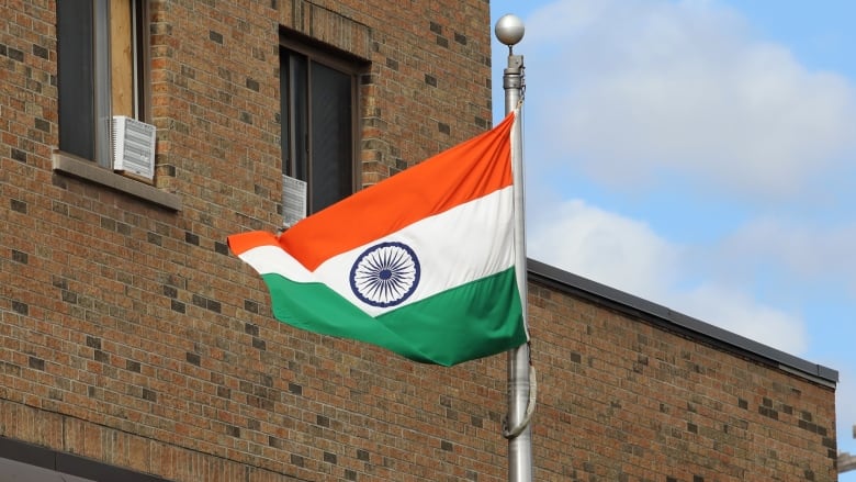 An Indian flag flies outside a building.