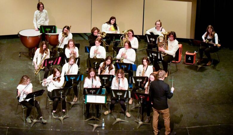 A young person's concert band is shown on stage.