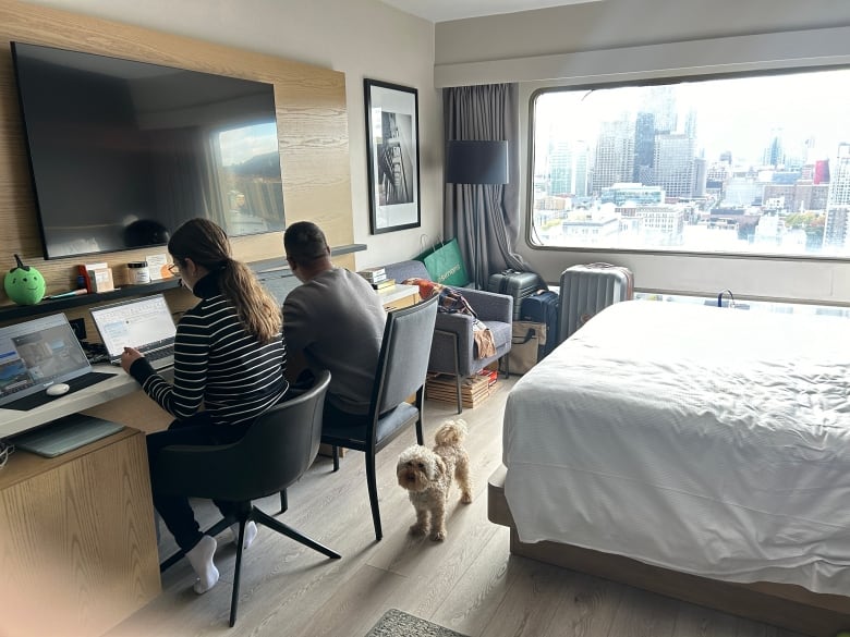 Louise Rivet and her partner working from a hotel room