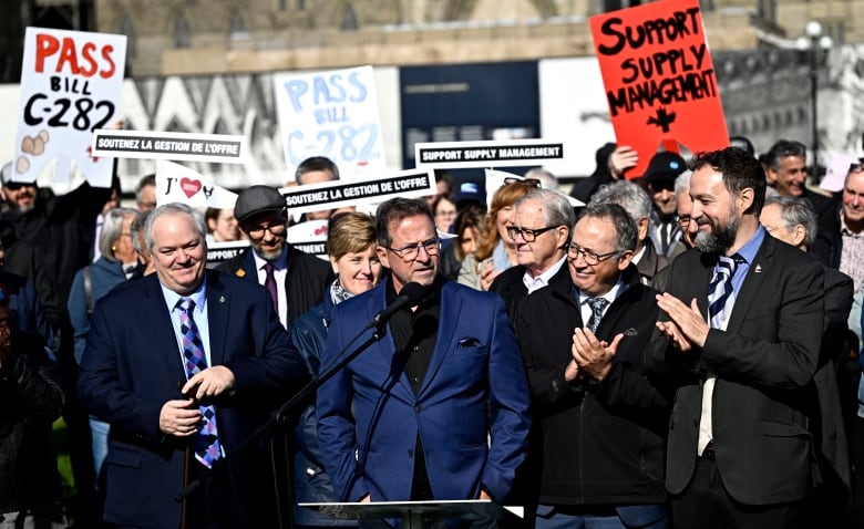 A crowd of people is pictured, clapping and applauding.