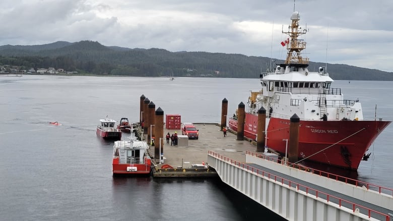 A red and white boat near a dock. 