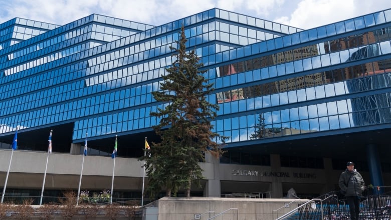 a glass building with 5 flags in front of it