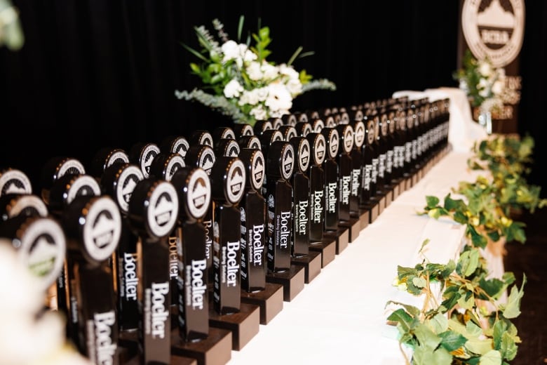 A long row of black awards trophies stretching from bottom left to the top right of the picture.