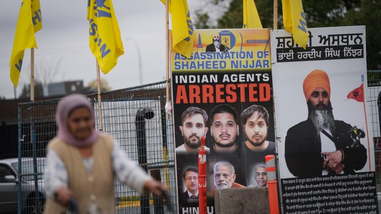 A photograph of late temple president Hardeep Singh Nijjar, back right, is seen outside the Guru Nanak Sikh Gurdwara Sahib in Surrey, B.C., on Tuesday, Oct. 15, 2024. Hardeep Singh Nijjar was assassinated in his vehicle while leaving the temple parking lot last year.