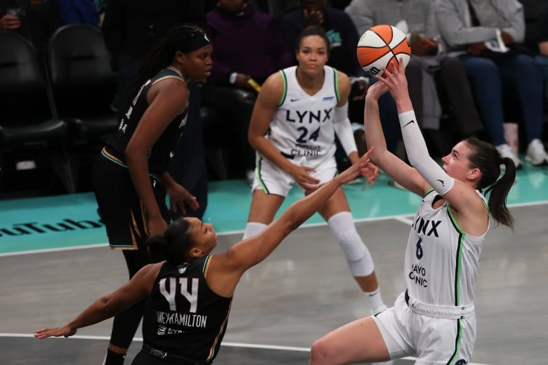 A woman shoots a basketball.