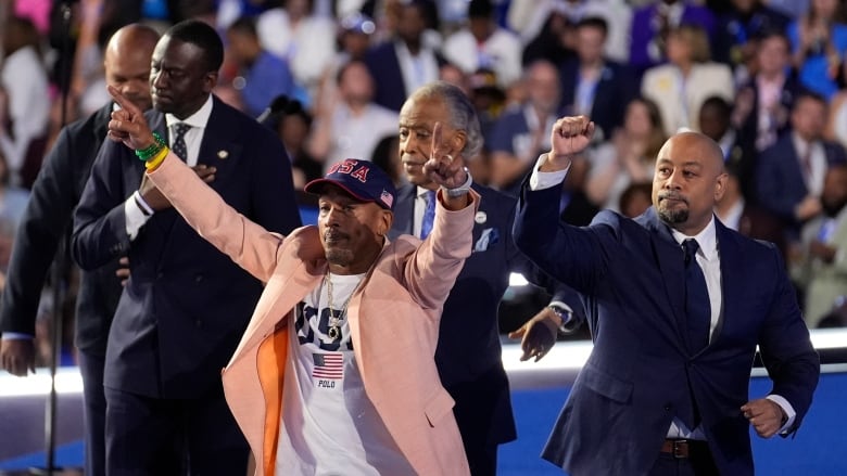 Five men stand on a stage