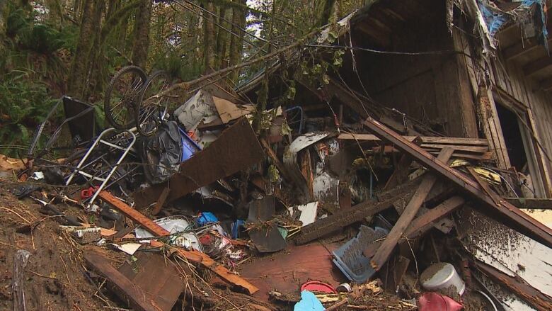 Debris and the wreckage of a house are seen among the mud.