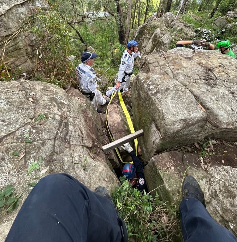 Rescuers work in  a  rocky crevice