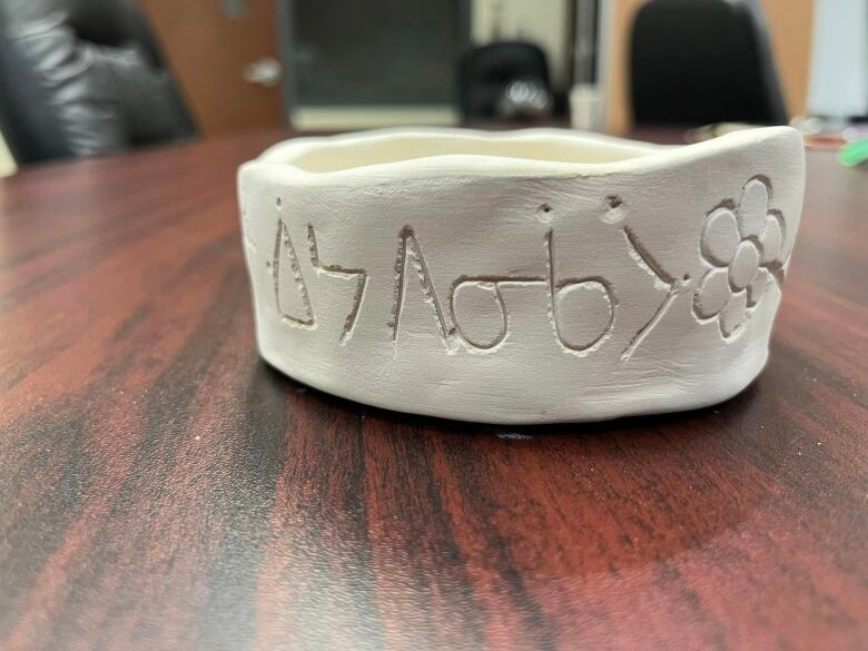 A cermic bowl with traditional Cree syllabics carved alongside