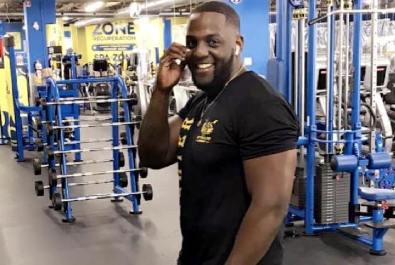 A man poses for a photo in a gym