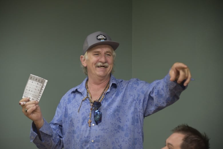 A man in a blue shirt smiles